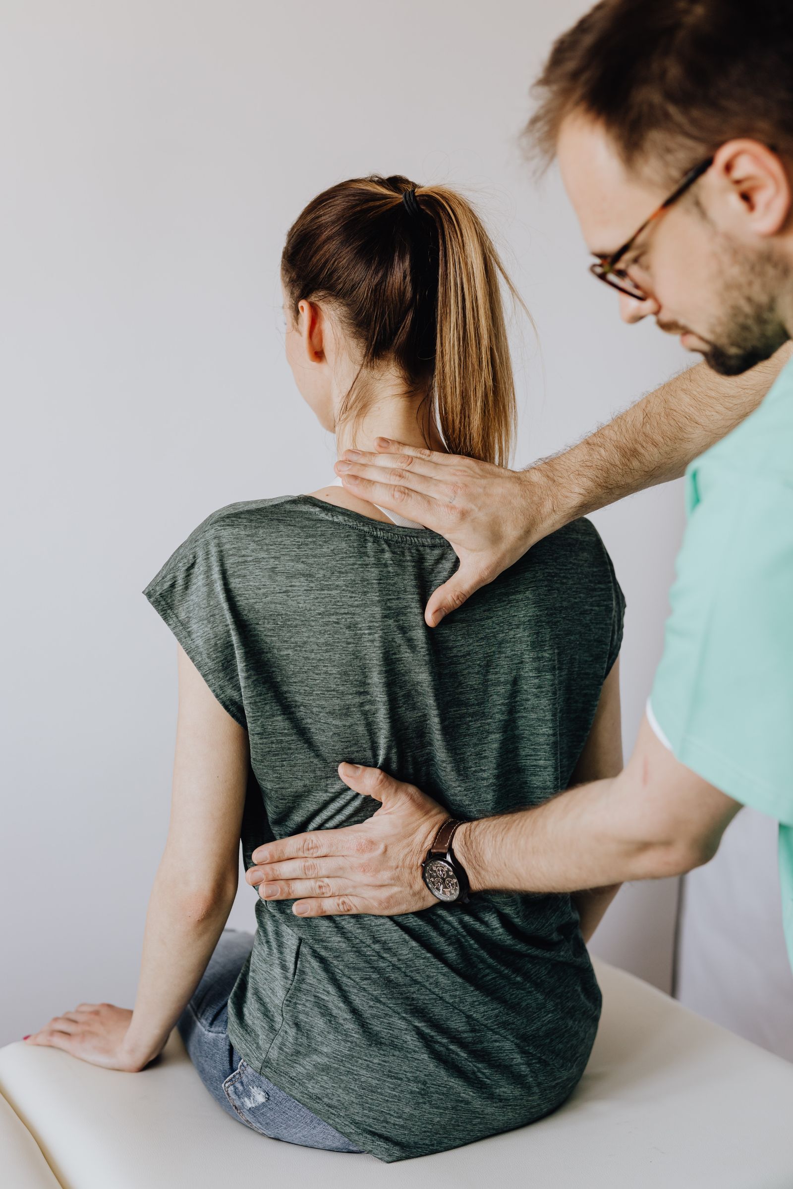 Clinician assessing cervical spine and neck