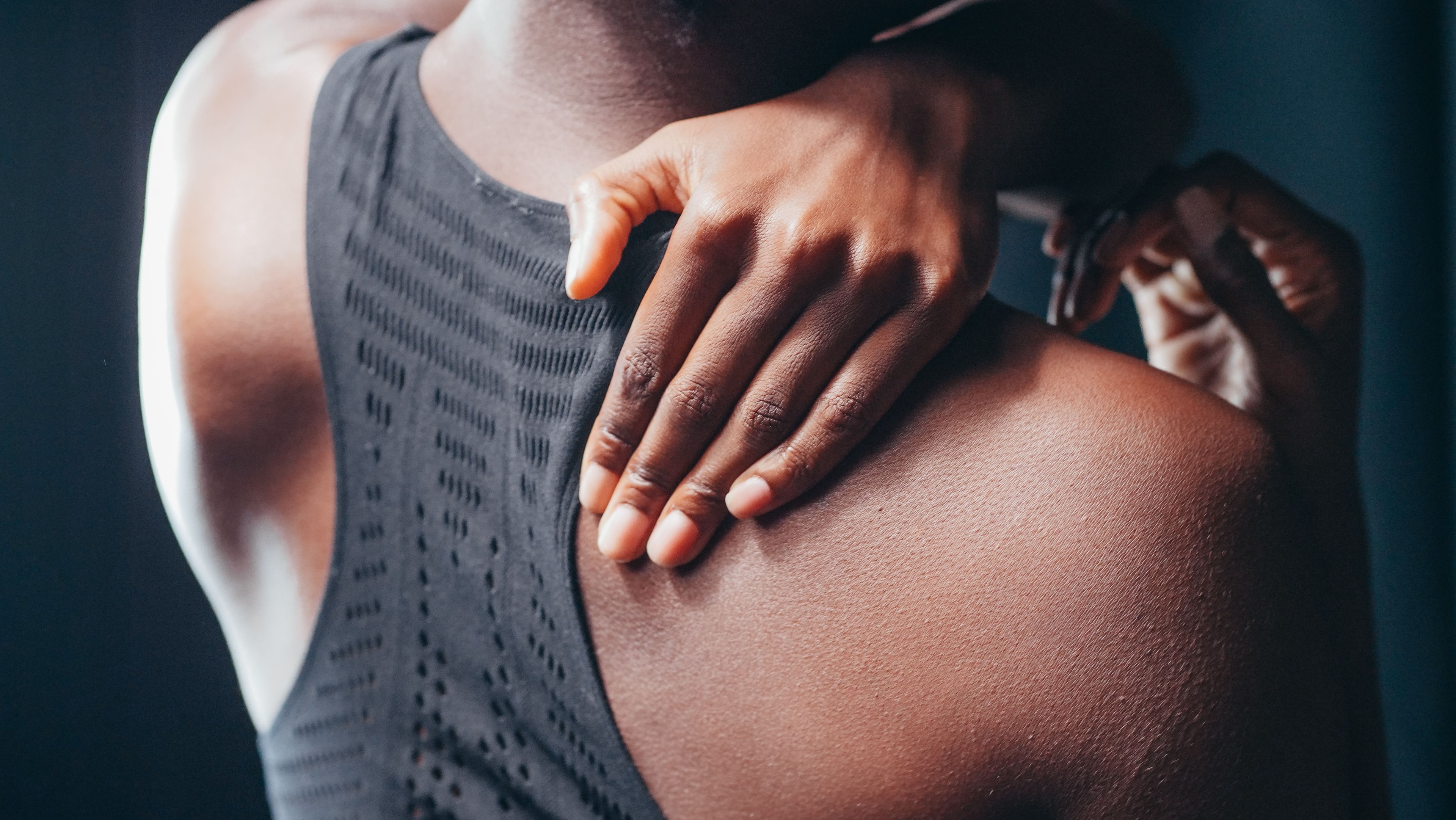Person holding shoulder in pain